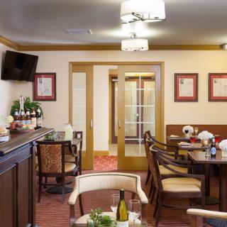 A cozy restaurant dining room with arranged tables and chairs, ambient lighting, and decorative elements.