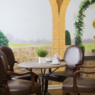 Cozy cafe seating area with a decorative wall mural and comfortable chairs.
