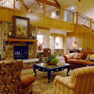 A cozy living room with a traditional design featuring a stone fireplace and comfortable seating.
