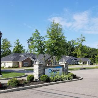 A quiet residential neighborhood with neatly landscaped houses and a welcoming entrance sign.