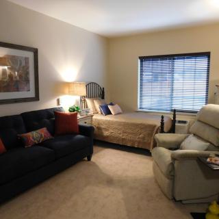 Cozy living space with a bed, sofa, and armchair.
