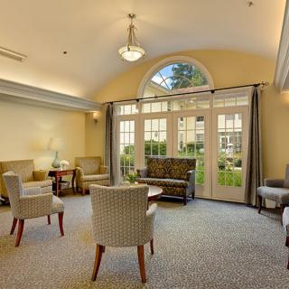 A spacious and well-lit living room with comfortable seating and large windows.