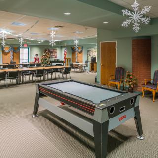 A spacious indoor recreation area featuring a pool table and festive decorations.