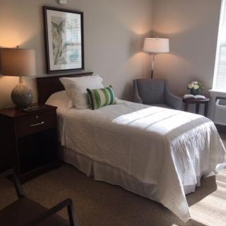 A cozy and minimalist bedroom with a single bed and modern decor.