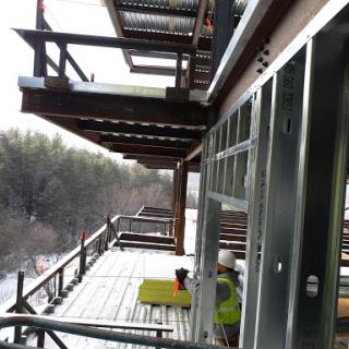 View of a construction site featuring multiple balconies on a winter day.