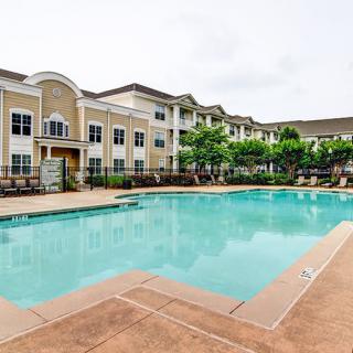A luxury apartment complex with a large outdoor swimming pool.