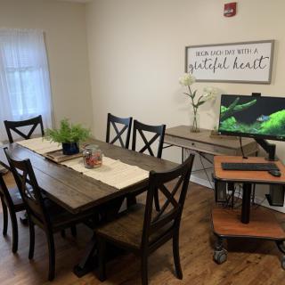 A cozy dining room with a wooden table, chairs, and decorative plants.
