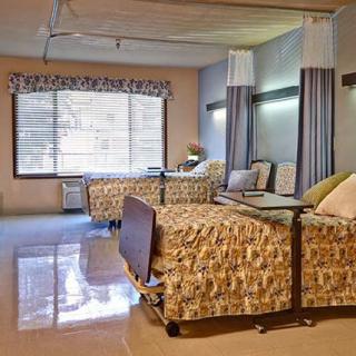 A hospital room with two beds and medical equipment.