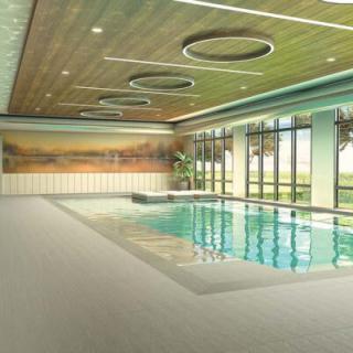 A modern indoor swimming pool area with large windows and stylish ceiling lighting.