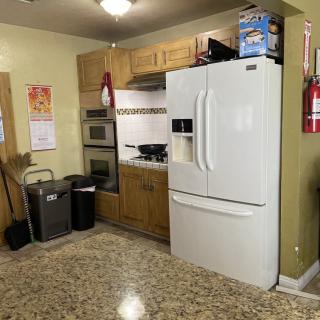 A kitchen with wooden cabinets and modern appliances, including a refrigerator and oven.
