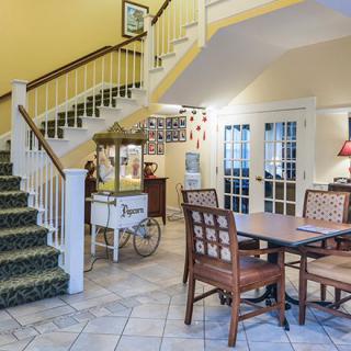 A cozy interior space featuring a staircase, dining table, and a vintage popcorn cart.
