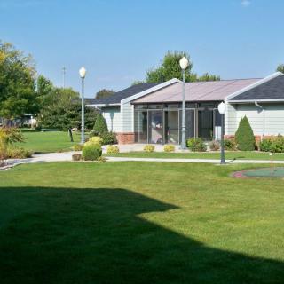 A tranquil outdoor scene featuring a building surrounded by a well-maintained lawn and garden.