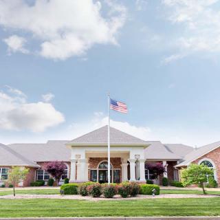 A well-maintained building with an American flag flying on the front lawn.