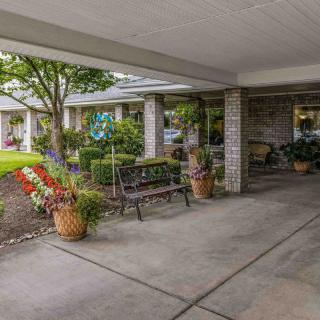 A covered entrance area with a bench and potted plants.