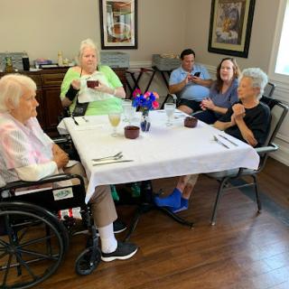 Seniors enjoying a meal together in a care facility.