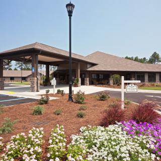 A welcoming residential facility with landscaped gardens and parking.