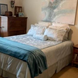 A cozy bedroom with a neatly made bed and wooden furniture.