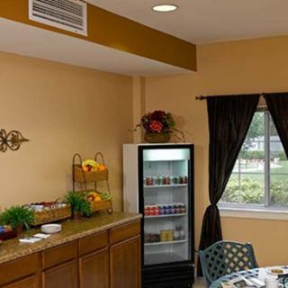 A cozy kitchen interior with a fridge, cabinets, and dining area.