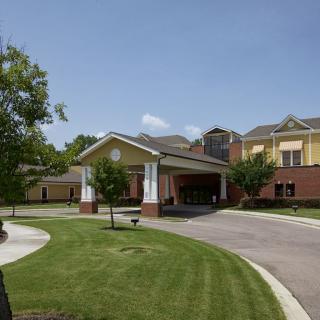 A modern building with a covered entrance and well-maintained landscaping.