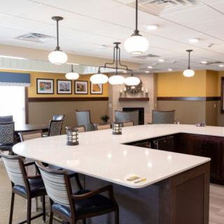 A modern conference room with a large table, comfortable chairs, and elegant lighting fixtures.