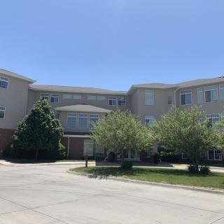 A suburban apartment complex on a sunny day with trees in front.