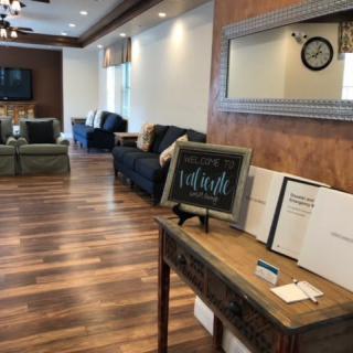 A well-appointed waiting area featuring comfortable seating, a large mirror, and elegant decor.