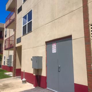 Exterior view of an apartment building on a sunny day.