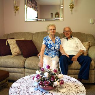 A cheerful elderly couple enjoying each other's company in their cozy living room.