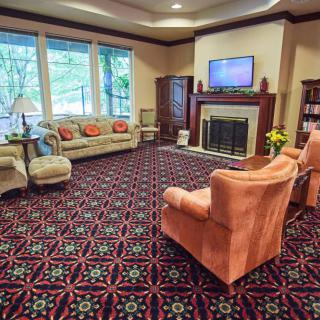 A cozy living room with comfortable seating, a fireplace, and large windows.