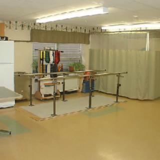 A physical therapy room equipped with parallel bars for rehabilitation exercises.