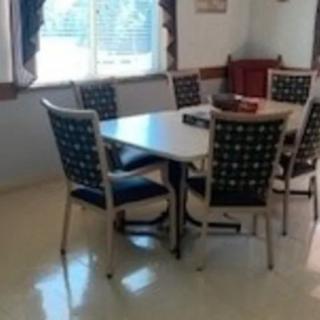 A bright dining area with a table and six chairs near a window.