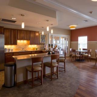 A modern kitchen and dining area with wooden furniture and soft lighting.