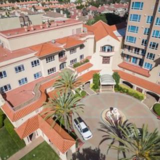 Aerial view of a hotel courtyard with palm trees and a parked vehicle.