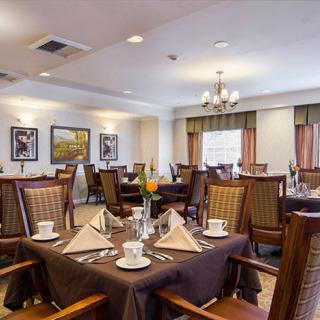 An elegantly set dining room with neatly arranged tables and chairs, ready for guests.