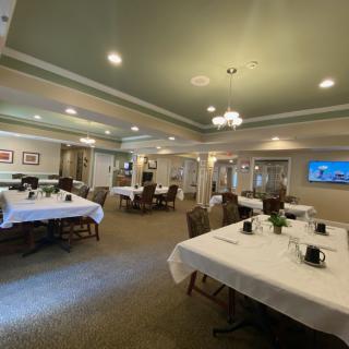 An elegant dining room with neatly arranged tables and a chandelier.