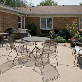 A cozy outdoor patio setup featuring a round table surrounded by metal chairs, perfect for relaxation and gatherings.