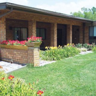 A brick house with a well-maintained garden and vibrant flowers.