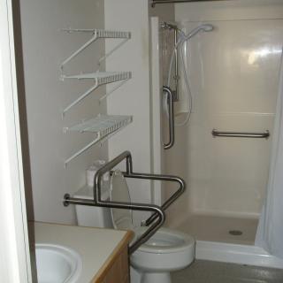 Accessible bathroom with grab bars and a walk-in shower.