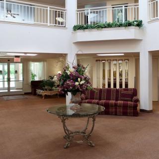 A spacious lobby with a central glass table adorned with a floral arrangement.