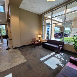 A cozy lobby with seating and large windows bringing in natural light.