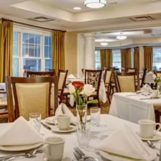 Elegant dining room with neatly set tables and chairs.