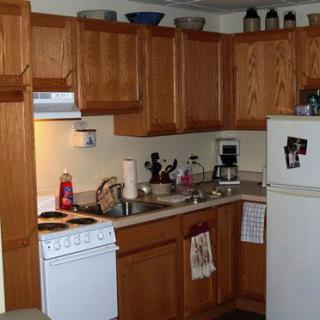 A cozy kitchen with wooden cabinets and various appliances.