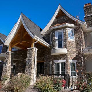 A beautifully designed stone house featuring distinctive architectural elements and a welcoming entrance.