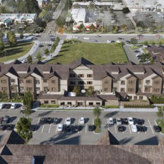 Aerial view of a large residential building with adjacent parking facilities.