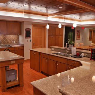 A modern kitchen featuring wooden cabinetry, a central island, and elegant lighting.