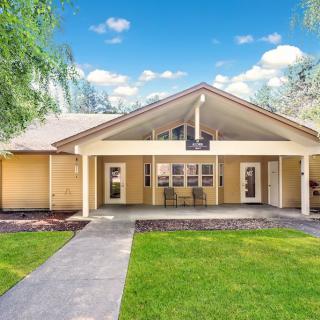 A charming single-story house with a neatly maintained front yard, complete with a lush lawn and a welcoming porch under a bright blue sky.