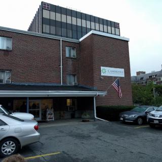 A brick building with a flag and parking lot, typical of an urban setting.