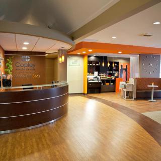 A modern hotel lobby featuring a reception desk and a cozy waiting area.