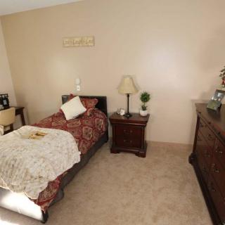 A cozy bedroom with a single bed, nightstand, and dresser.