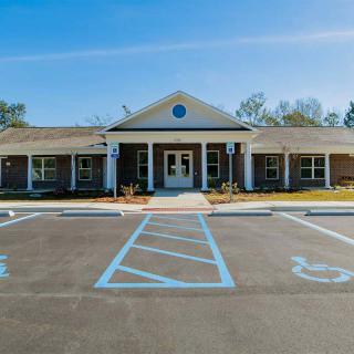 A single-story building with a large entrance and accessible parking spaces in front.
